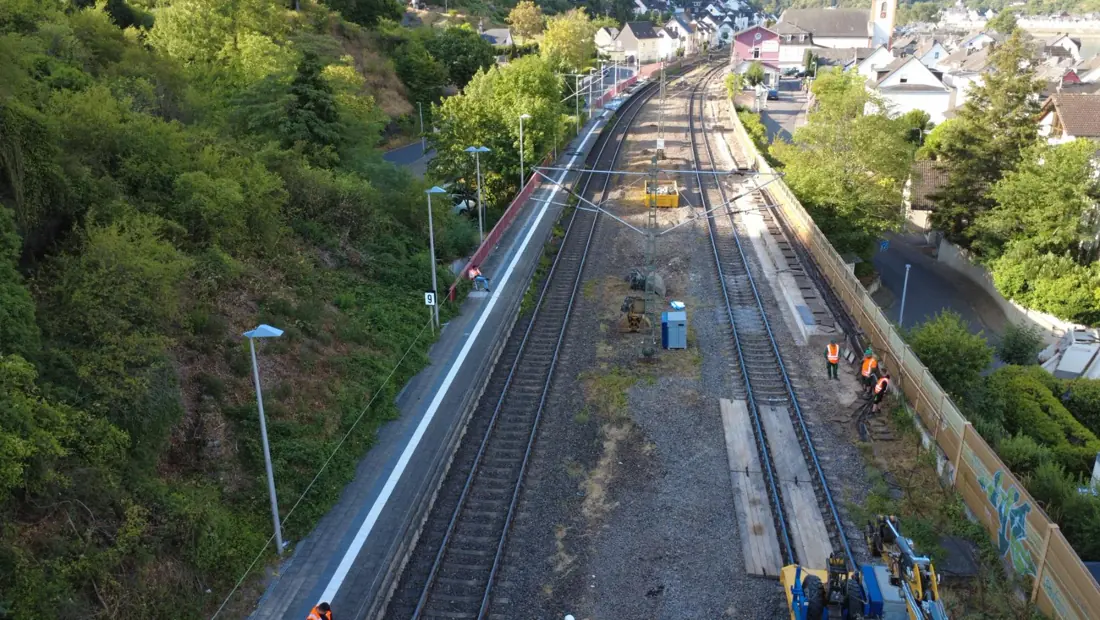 Bahnsteig und Gleisanlagen in Kestert aus der Luft, Bautrupp im Gleisbereich